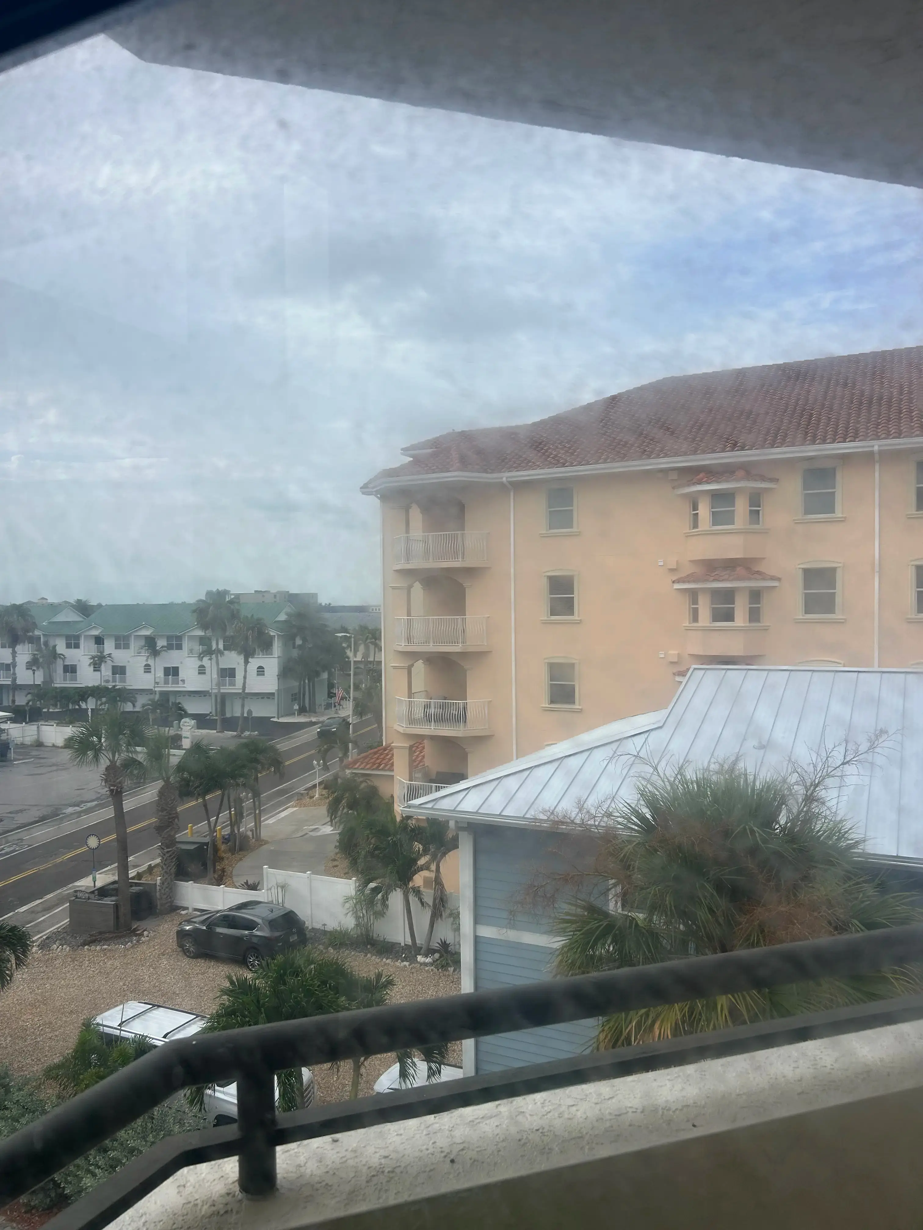 Condo balcony window before cleaning with haze across the view