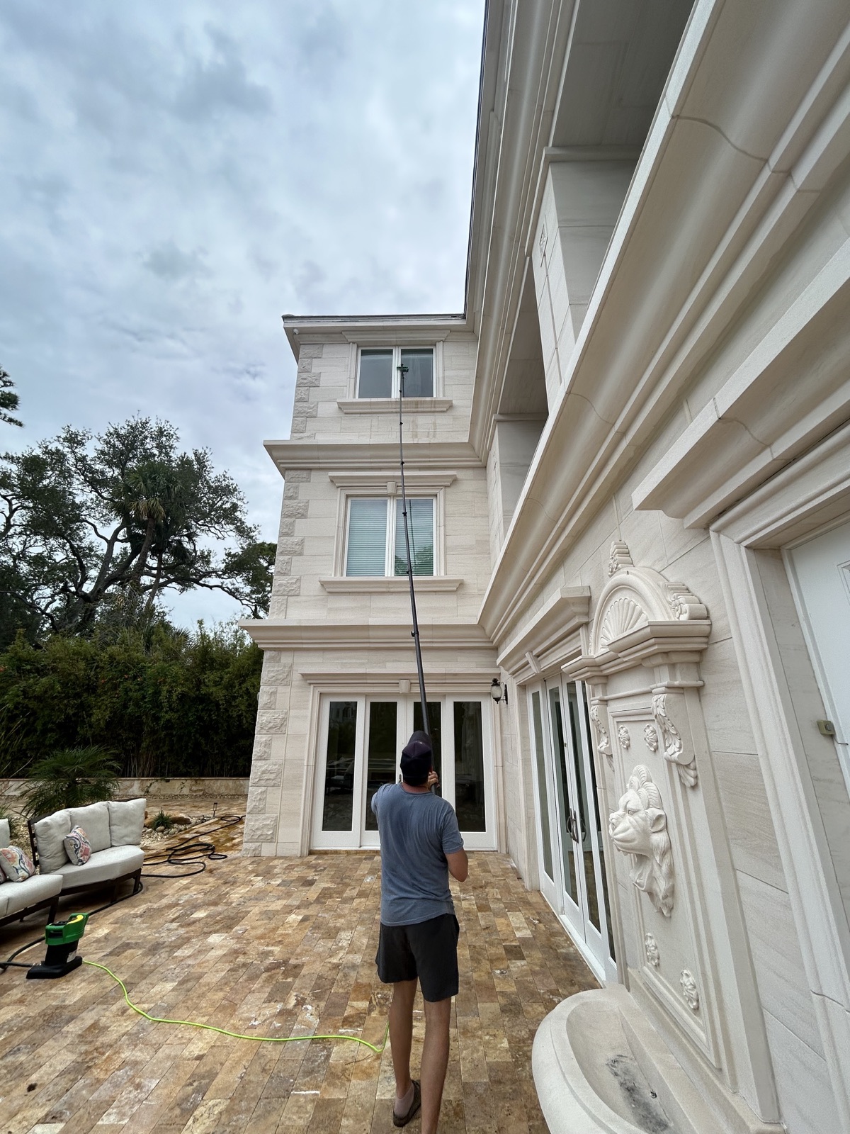Luke Warner using a water-fed pole to clean upper-story windows