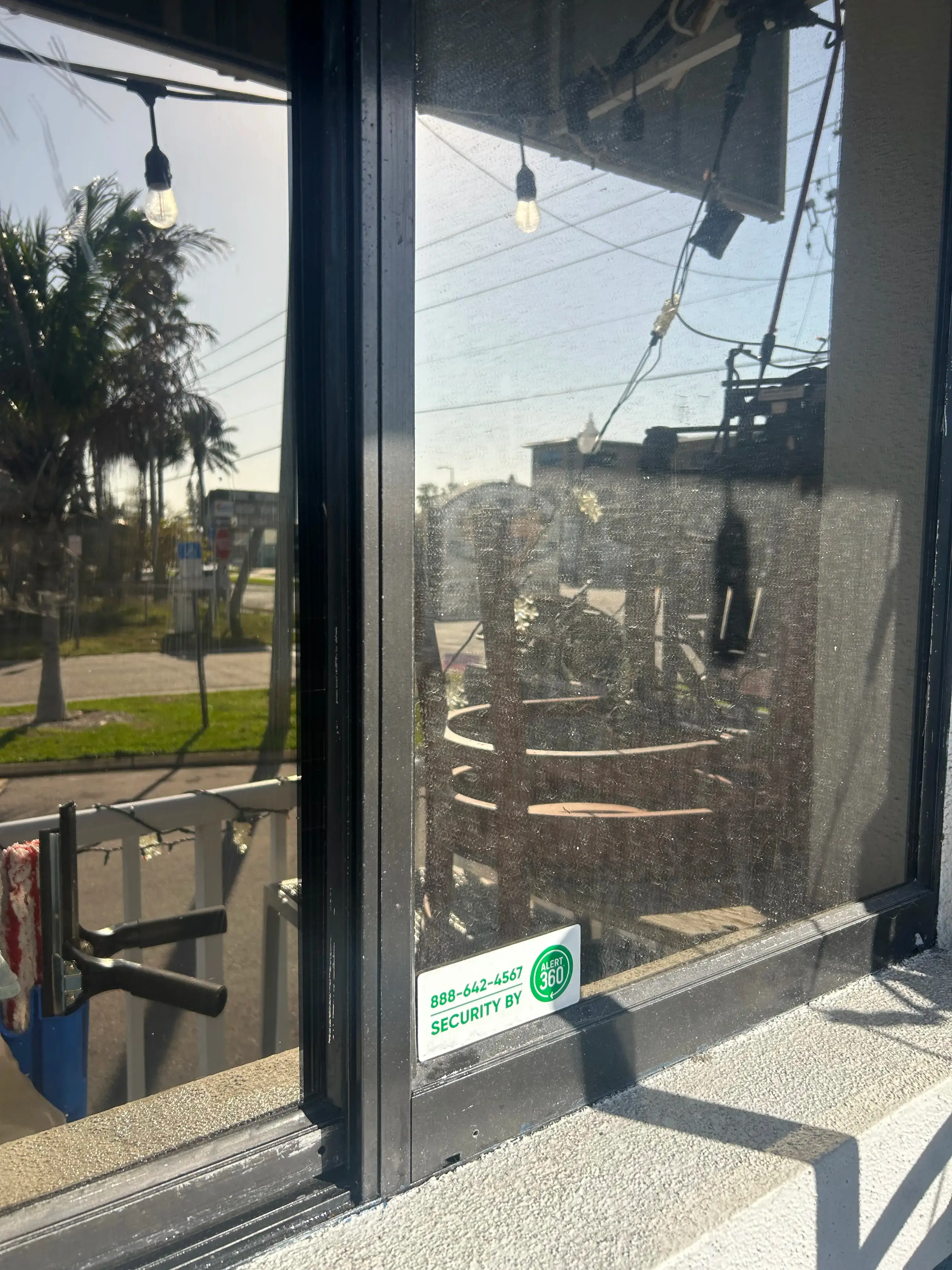 Restaurant window before commercial cleaning with visible buildup and haze
